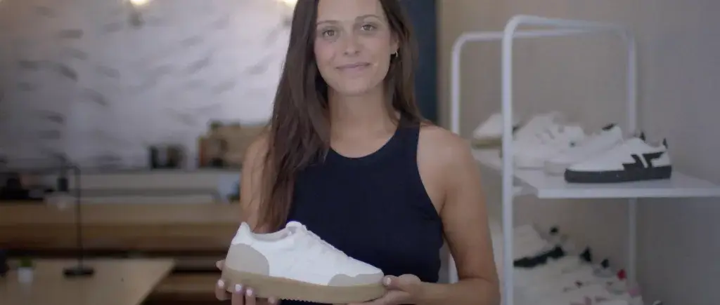 Laure Babin, fondatrice de Zeta, tenant une chaussure Zeta dans ses bureaux.